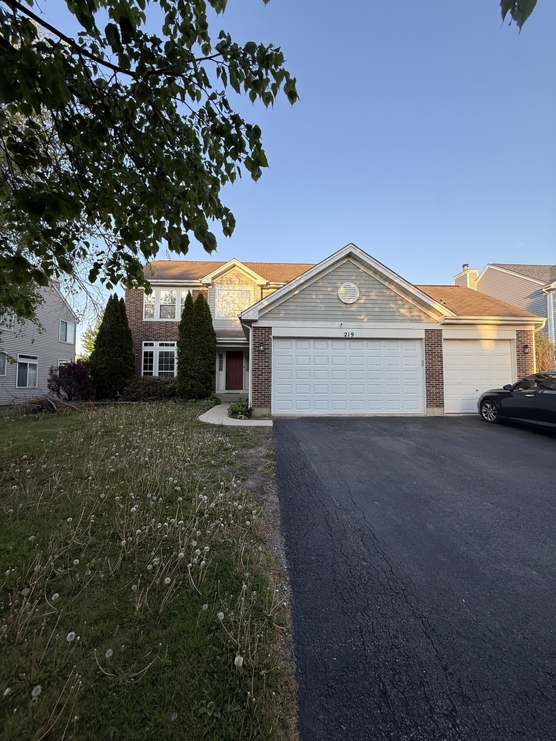 219 Primrose Lane Round Lake, IL 60073 - Photo 1 of 1 a front view of a house with a yard and garage