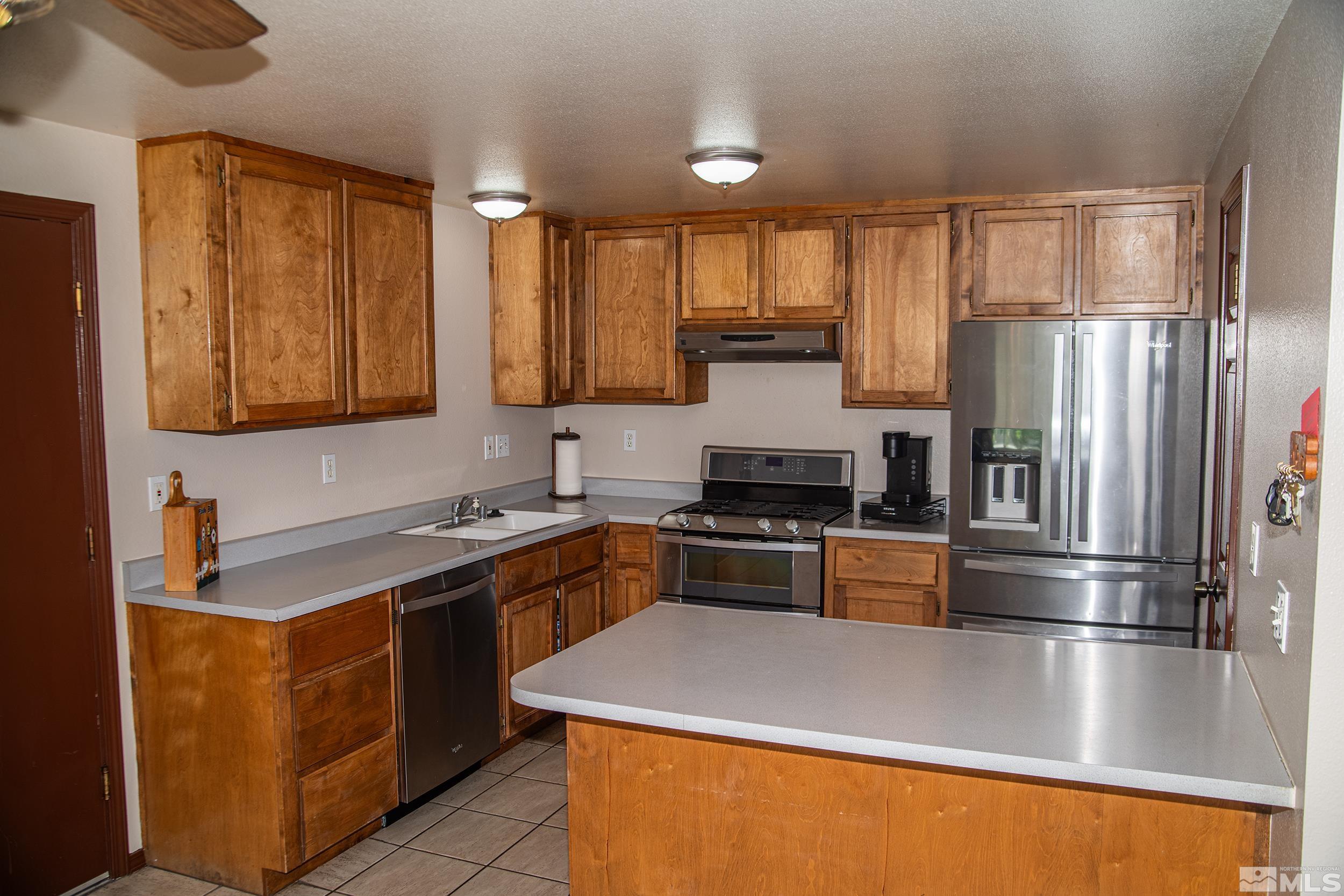 2525 Ridgecrest Drive Carson City, NV 89706 - Photo 7 of 21 a kitchen with stainless steel appliances granite countertop a stove a refrigerator and a sink