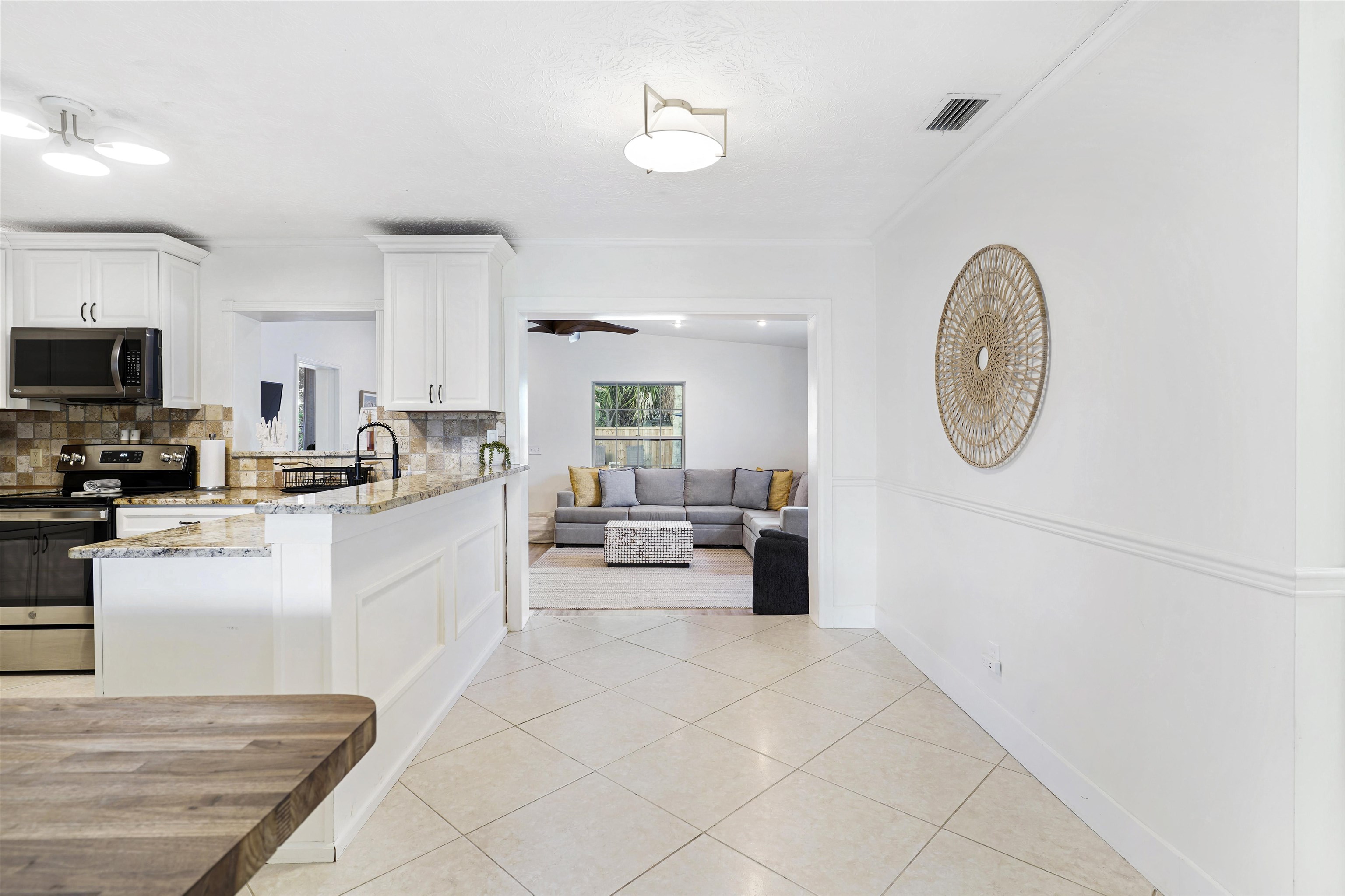 5436 4th Street St. Augustine, FL 32080 - Photo 15 of 45 a large white kitchen with a couch a stove a sink and a dining table