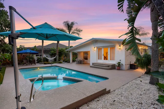 a view of a house with swimming pool and sitting area