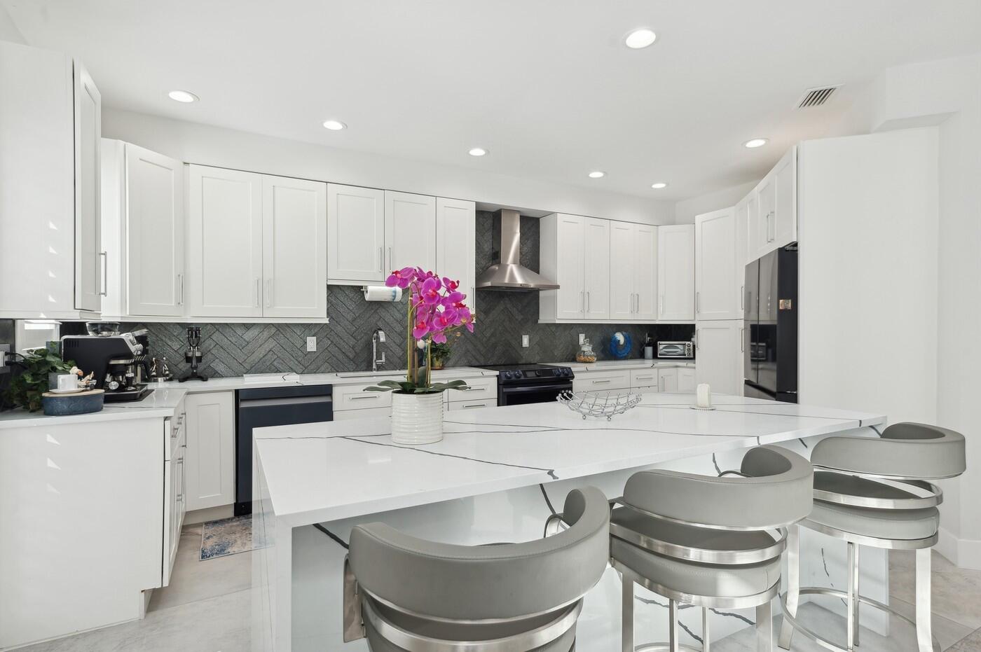 2558 Northwest 52nd Street Boca Raton, FL 33496 - Photo 9 of 27 a kitchen with a stove a sink and a refrigerator