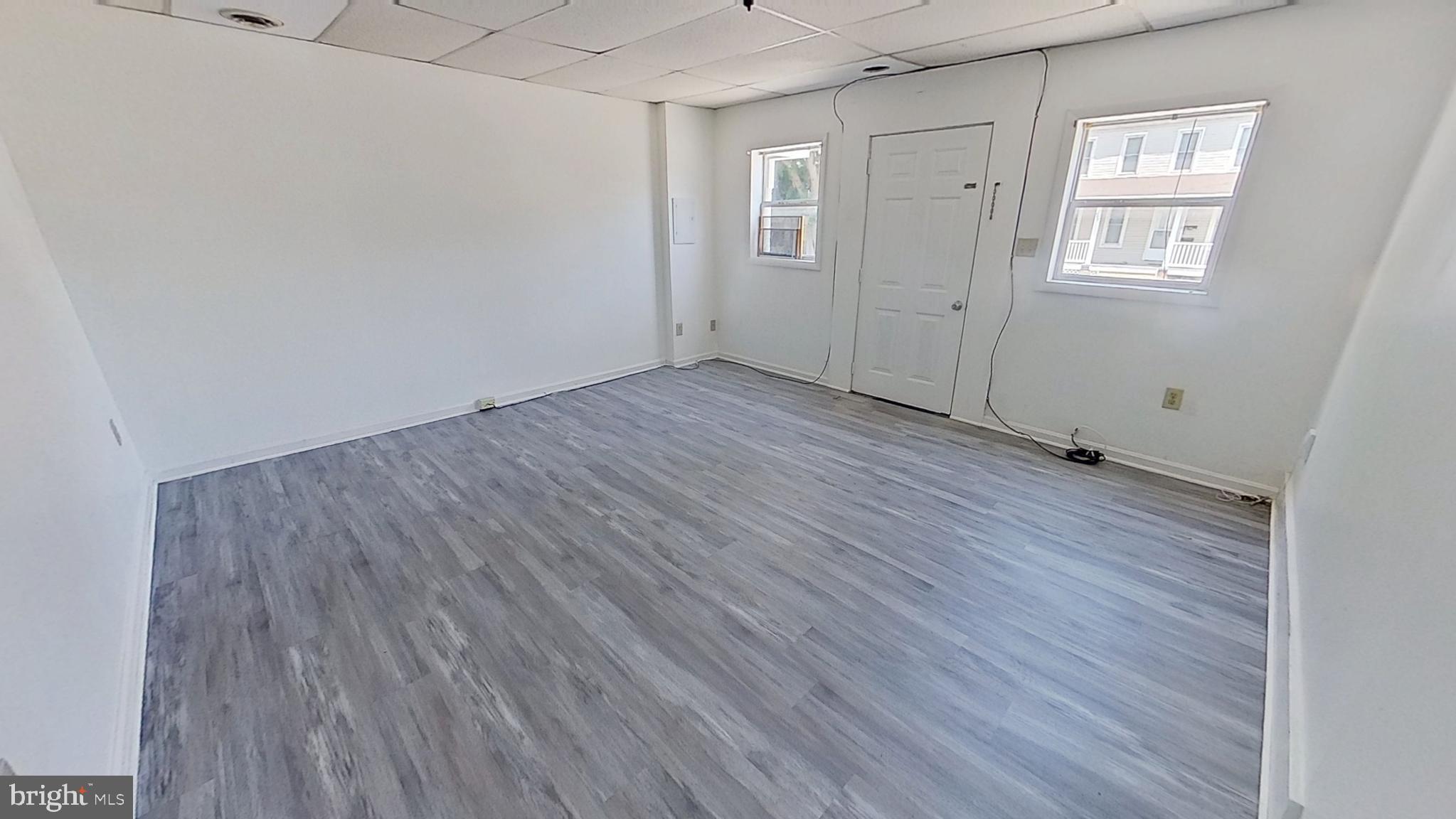 648 Broadway, Unit A Hanover, PA 17331 - Photo 2 of 10 an empty room with wooden floor and windows