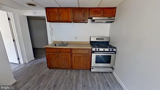 a kitchen with stainless steel appliances a stove a microwave and wooden floor