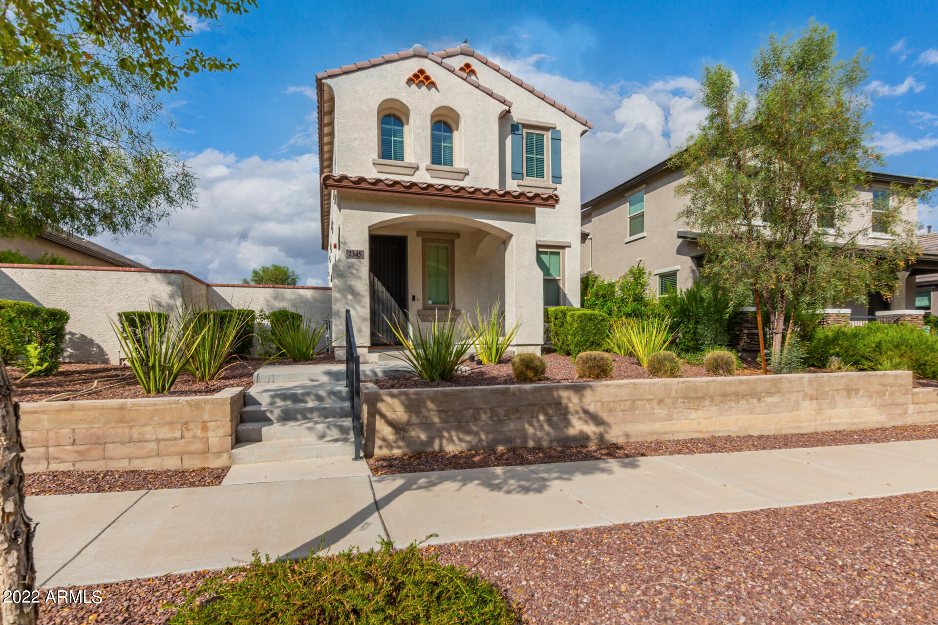 2345 North Alsap Road Buckeye, AZ 85396 - Photo 3 of 50 a view of a white house with a small yard plants and a fountain