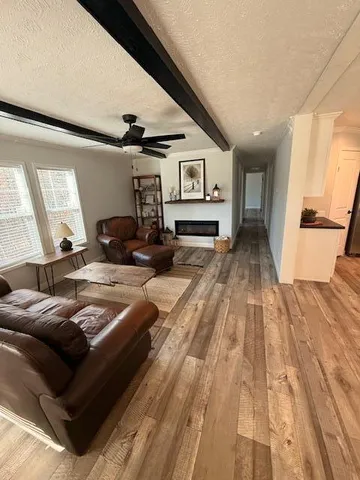 a living room with furniture and a wooden floor