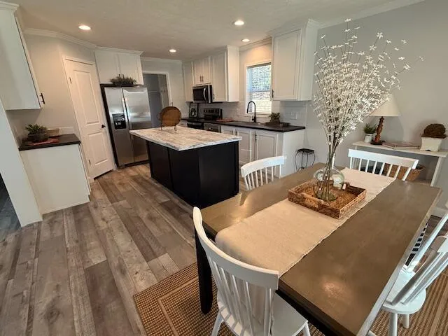 a kitchen with a table chairs a sink and a refrigerator