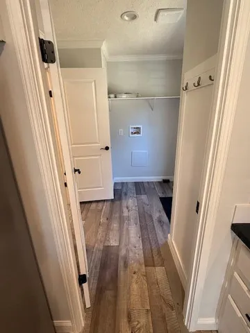 a view of walk in closet with wooden floor and door