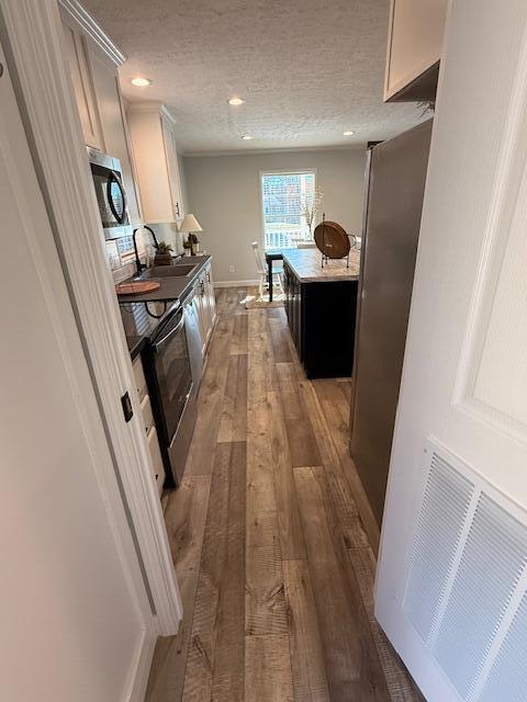2475 Coles Creek Road Rocky Mount, VA 24151 - Photo 21 of 42 a hallway with a white stove top oven and a dishwasher with wooden floor