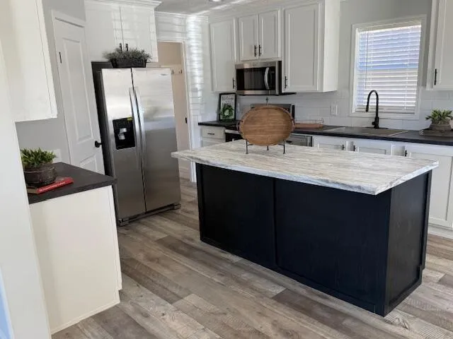 a kitchen with stainless steel appliances a sink cabinets and refrigerator