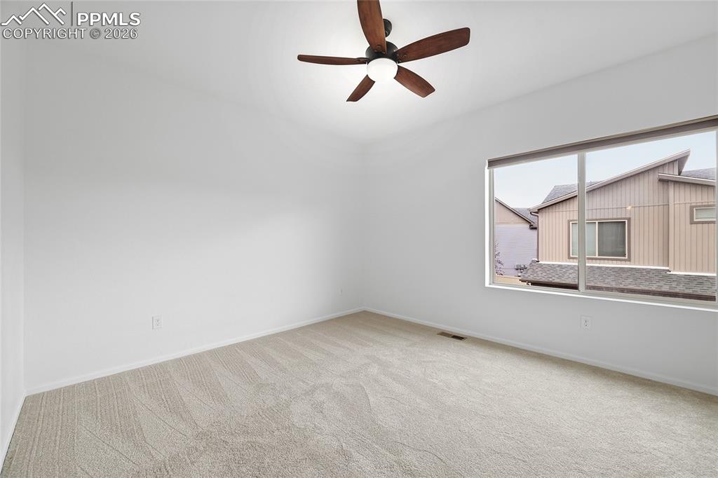 9414 Timberlake Loop Colorado Springs, CO 80927 - Photo 17 of 40 Unfurnished primary bedroom with light carpet and a ceiling fan