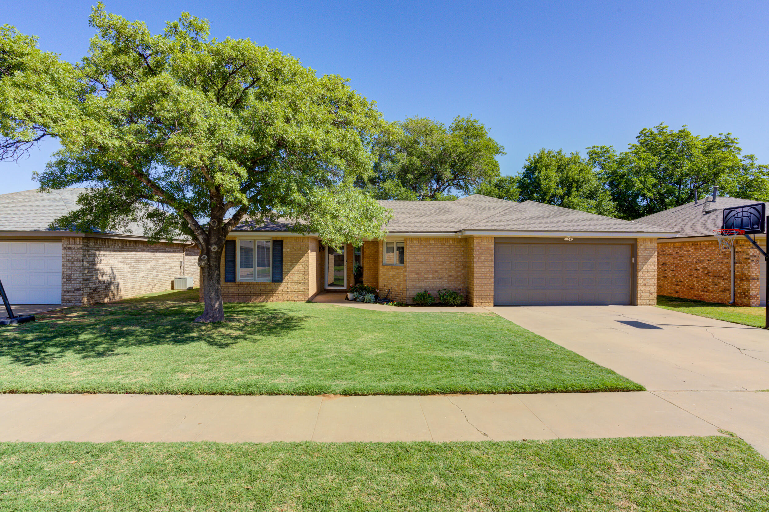 3712 103rd Street Lubbock, TX 79423 - Photo 1 of 43 a front view of a house with a yard and a garage