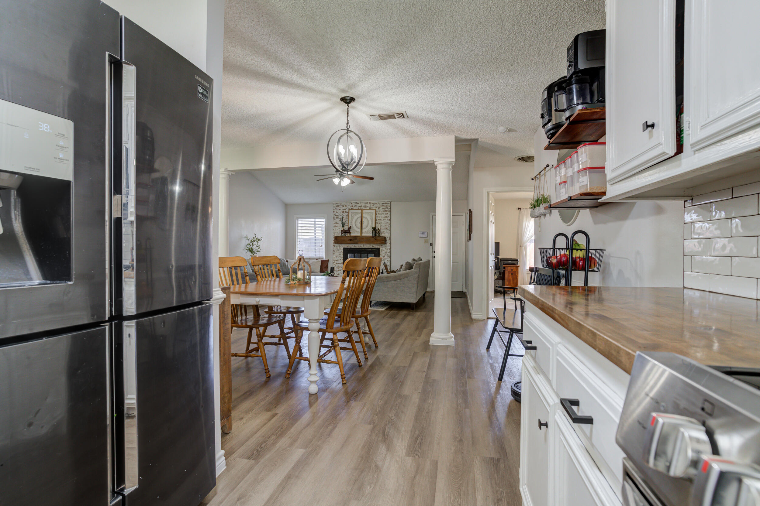 3712 103rd Street Lubbock, TX 79423 - Photo 19 of 43 a kitchen with stainless steel appliances granite countertop a refrigerator a sink dishwasher a stove and a dining table with wooden floor