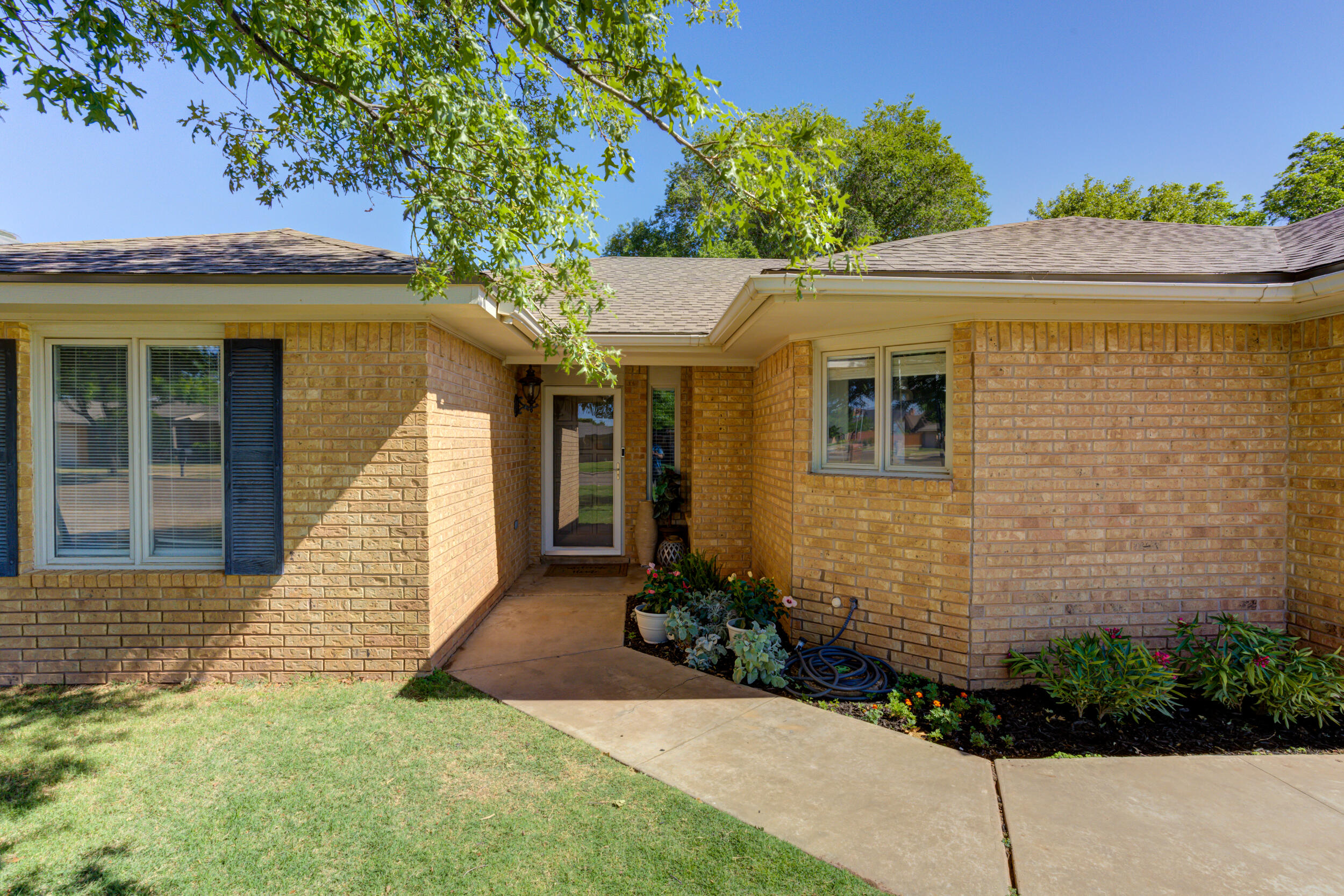 3712 103rd Street Lubbock, TX 79423 - Photo 2 of 43 a front view of a house with garden