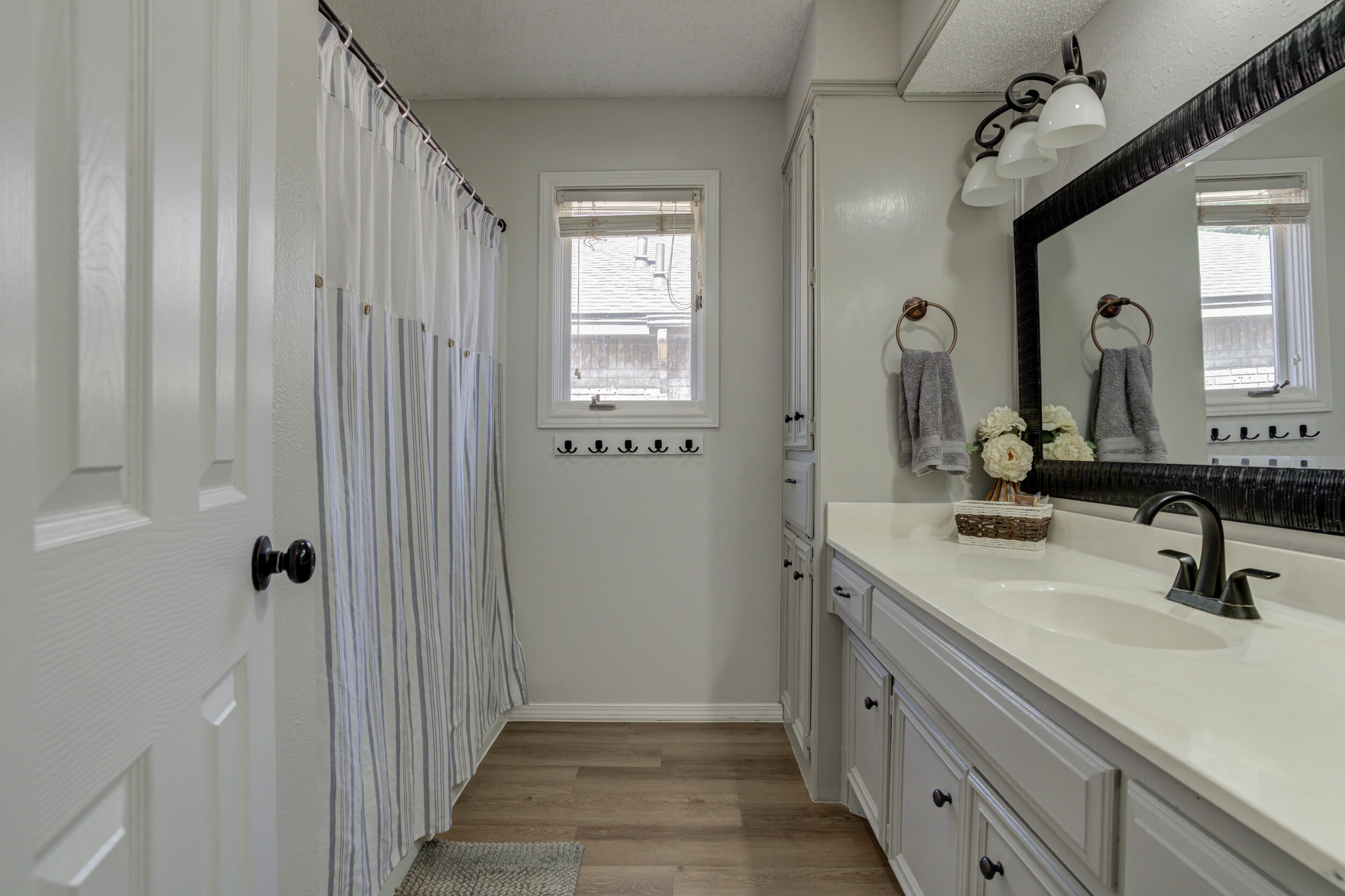 3712 103rd Street Lubbock, TX 79423 - Photo 21 of 43 a bathroom with a double vanity sink and a mirror