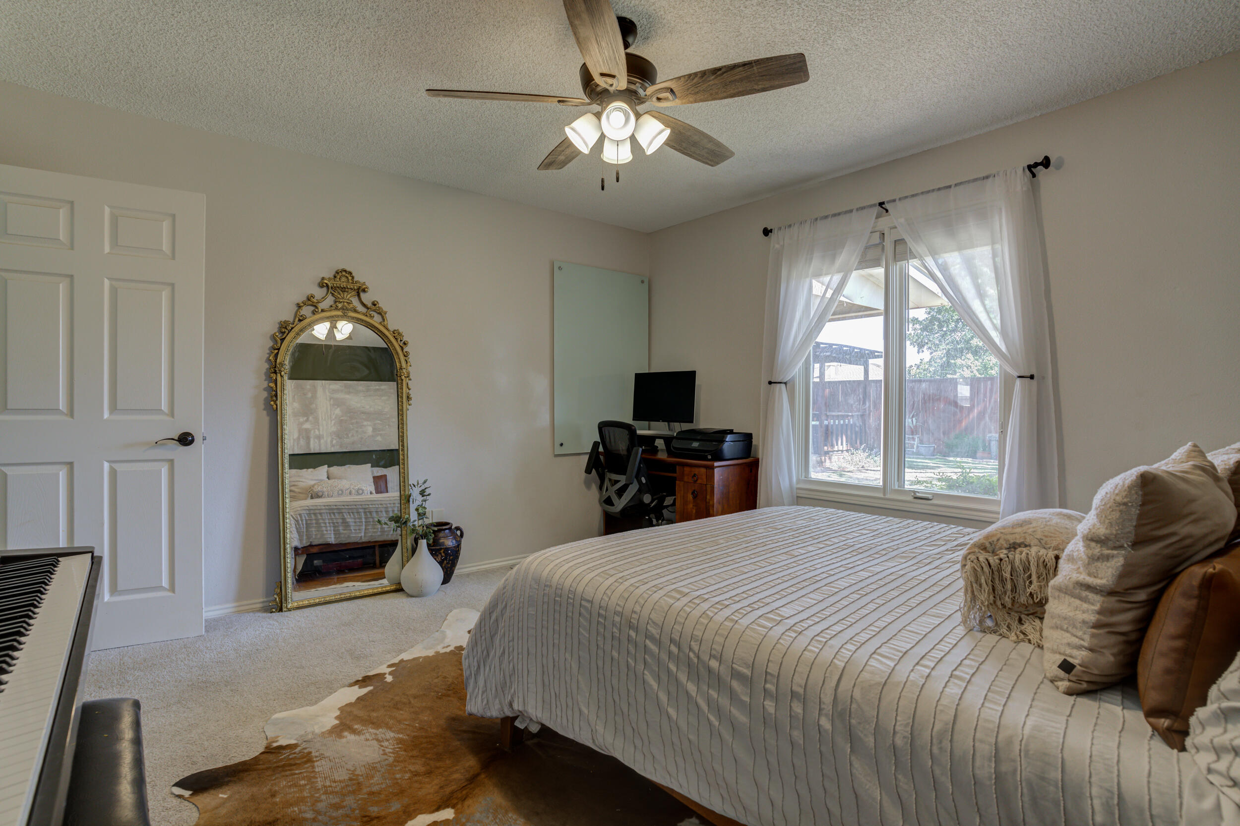3712 103rd Street Lubbock, TX 79423 - Photo 28 of 43 a bedroom with a bed and a chandelier