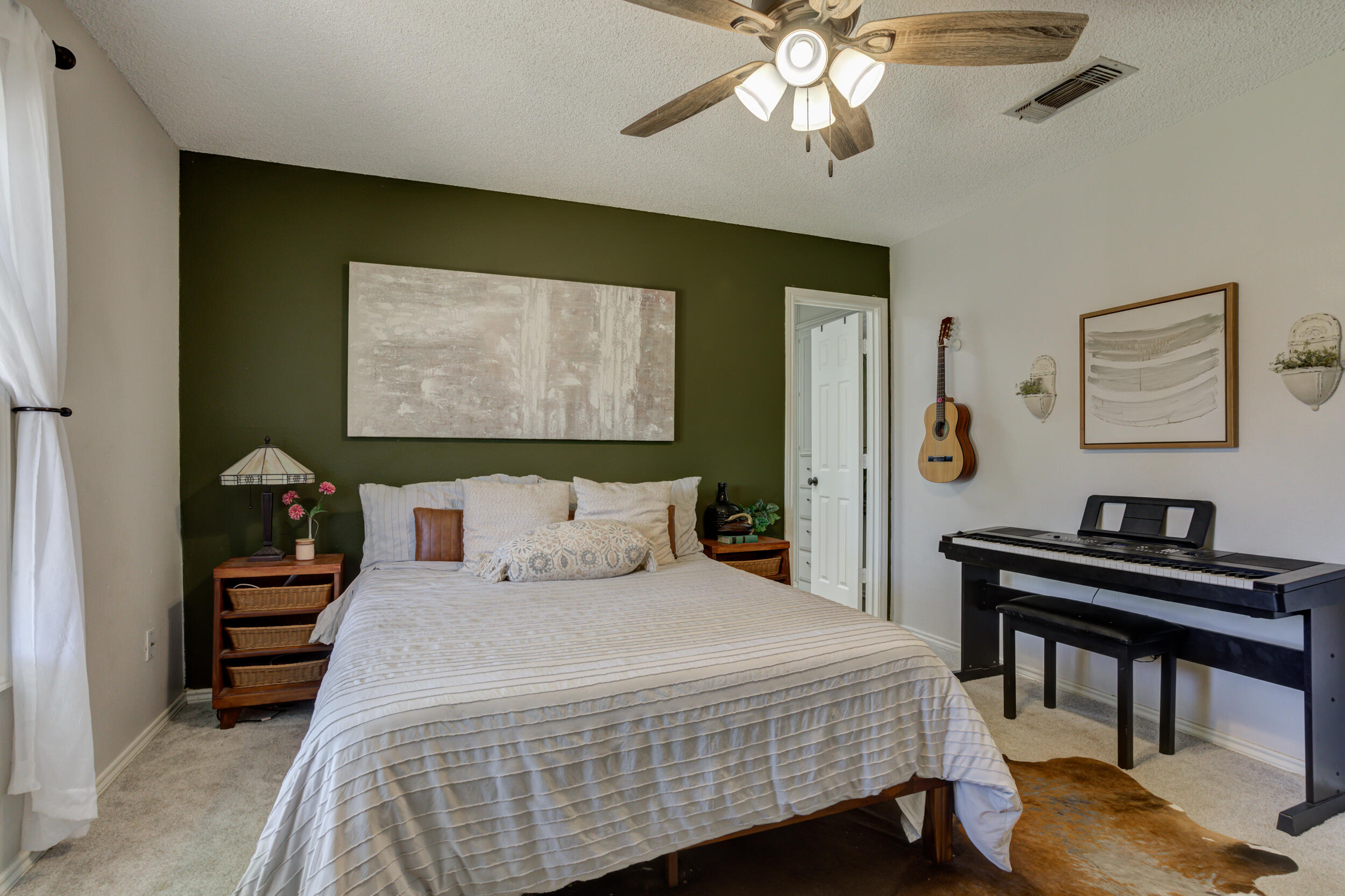 3712 103rd Street Lubbock, TX 79423 - Photo 29 of 43 a bedroom with a bed and a chandelier