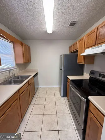 a kitchen with stainless steel appliances granite countertop a stove a refrigerator and a cabinets