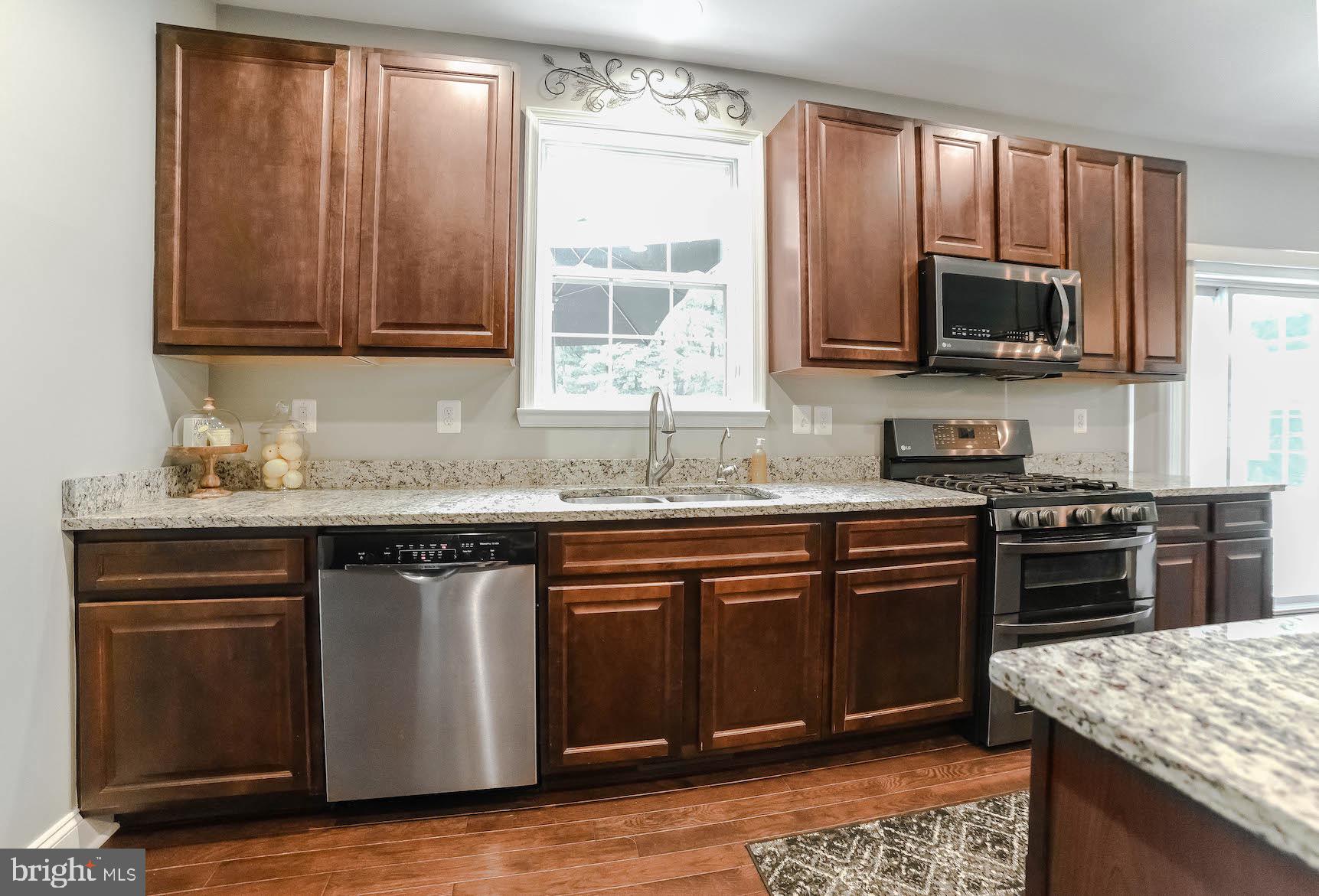 2160 Lowery Road Huntingtown, MD 20639 - Photo 12 of 53 a kitchen with stainless steel appliances granite countertop a stove a sink and a microwave