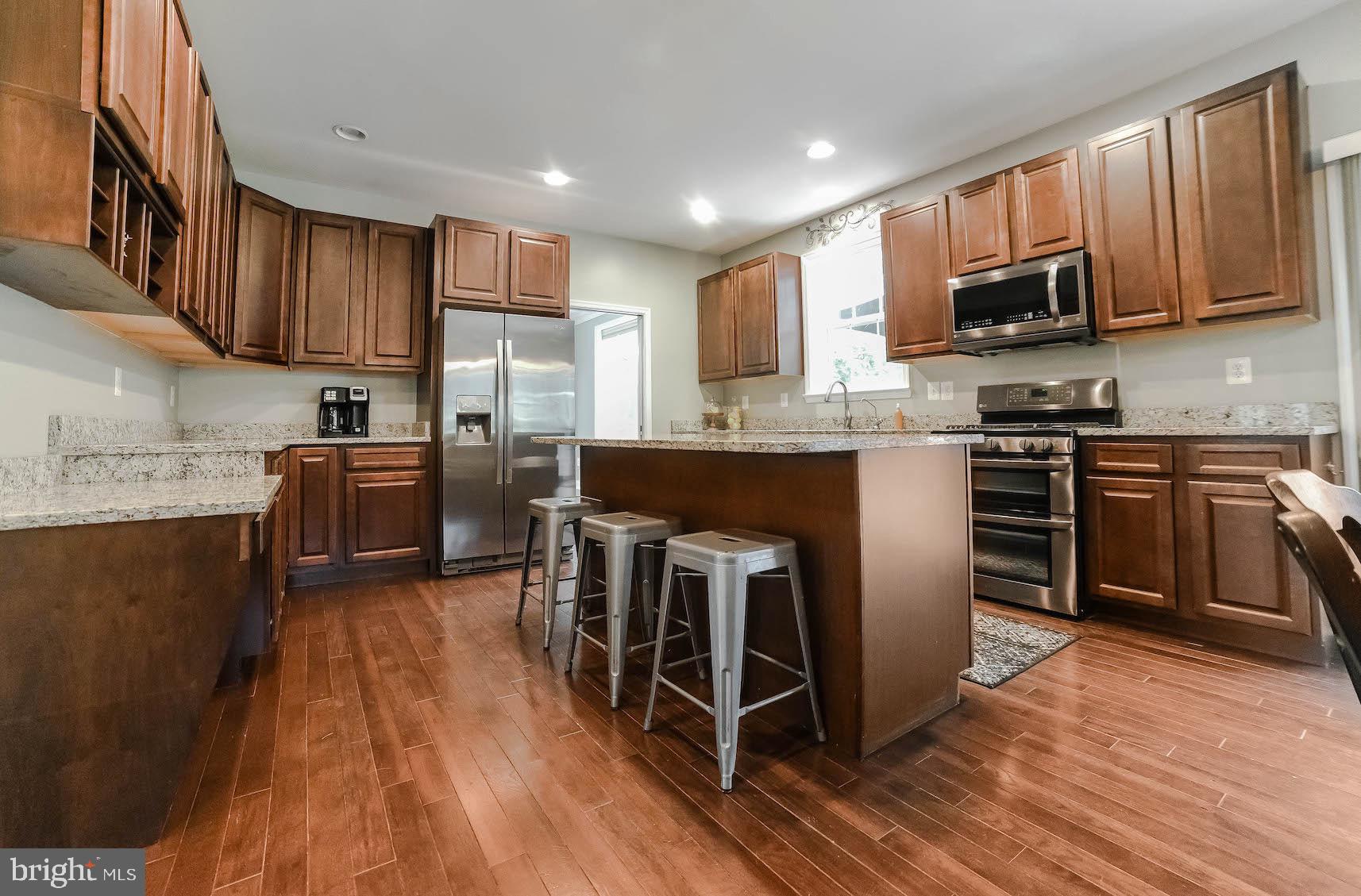 2160 Lowery Road Huntingtown, MD 20639 - Photo 13 of 53 a kitchen with stainless steel appliances granite countertop wooden floors a stove top oven a sink and dishwasher
