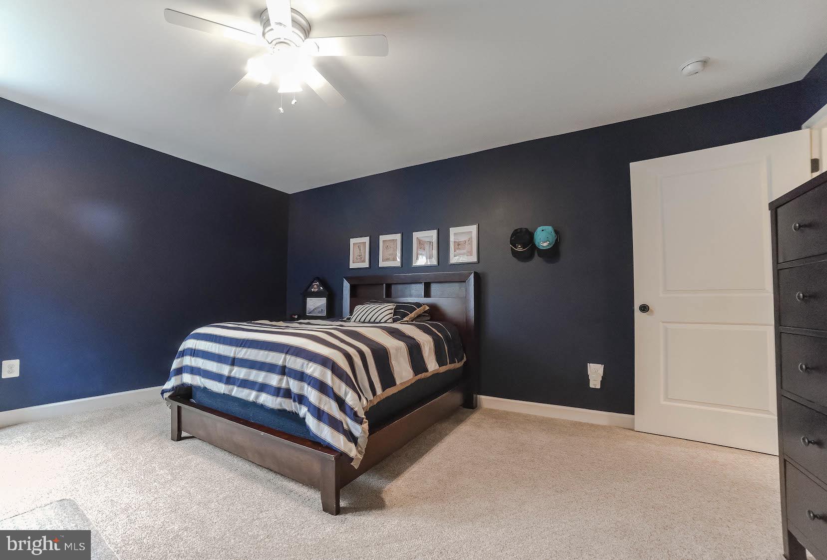 2160 Lowery Road Huntingtown, MD 20639 - Photo 25 of 53 a spacious bedroom with a bed and a chandelier