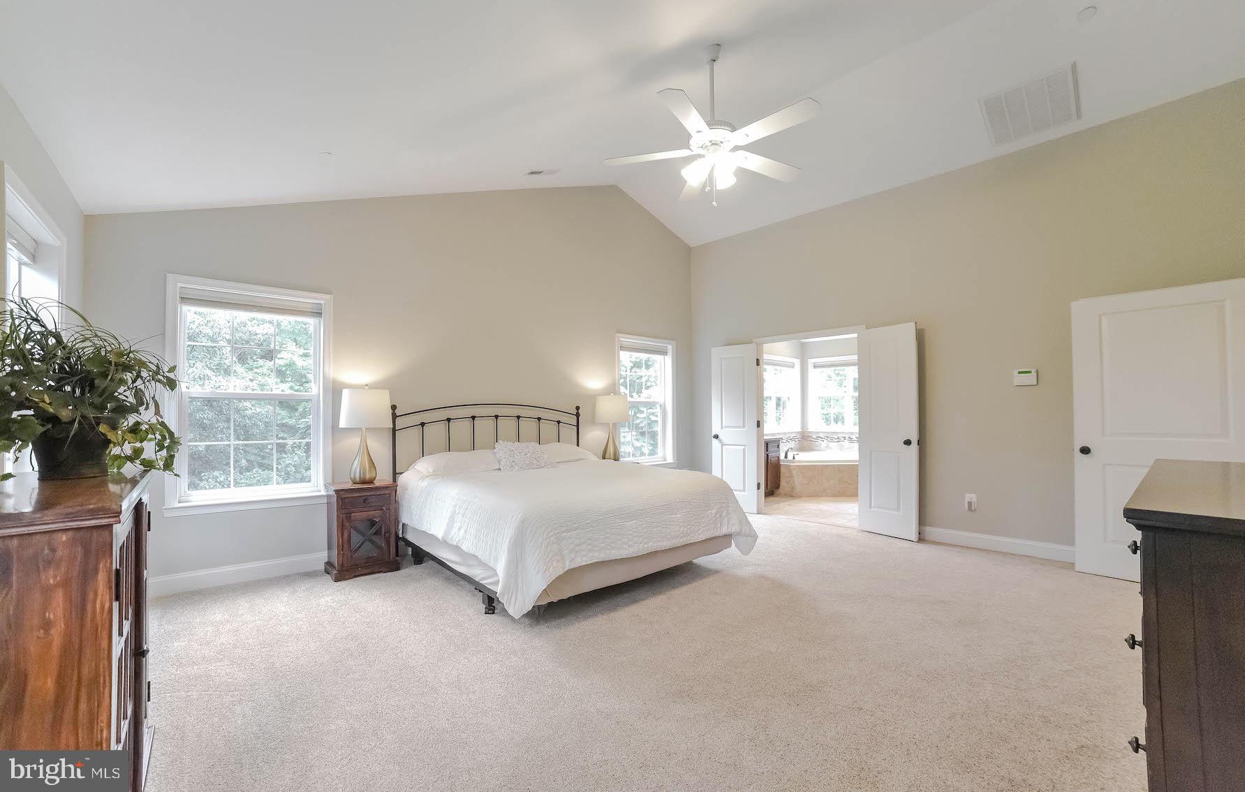 2160 Lowery Road Huntingtown, MD 20639 - Photo 33 of 53 a spacious bedroom with a large bed and a chandelier
