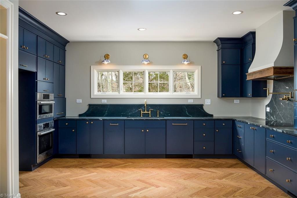 8268 Ballard Road Colfax, NC 27235 - Photo 11 of 50 a deep basin farmhouse sink framed by timeless sconces