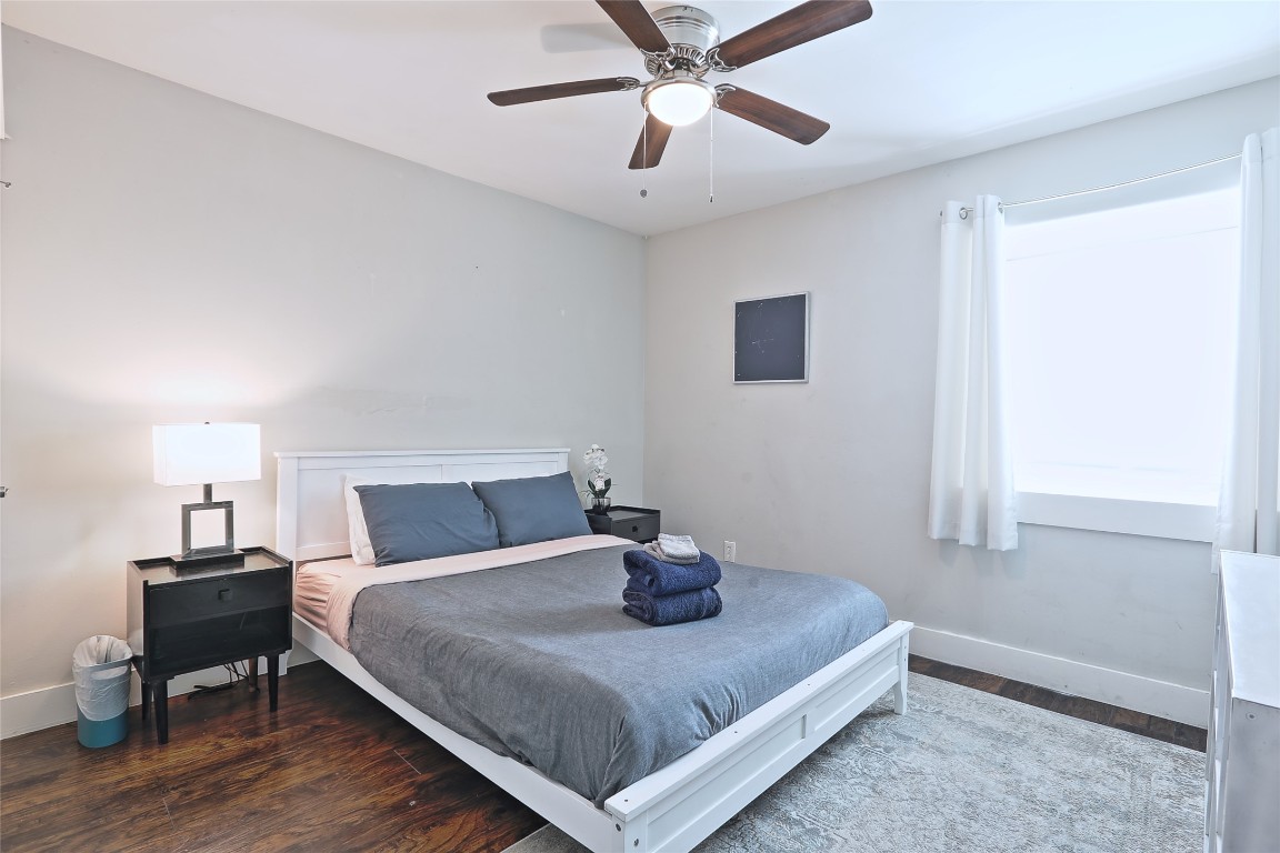 4804 West Wind Trail, Unit 102 Austin, TX 78745 - Photo 13 of 24 a bedroom with a bed and wooden floor