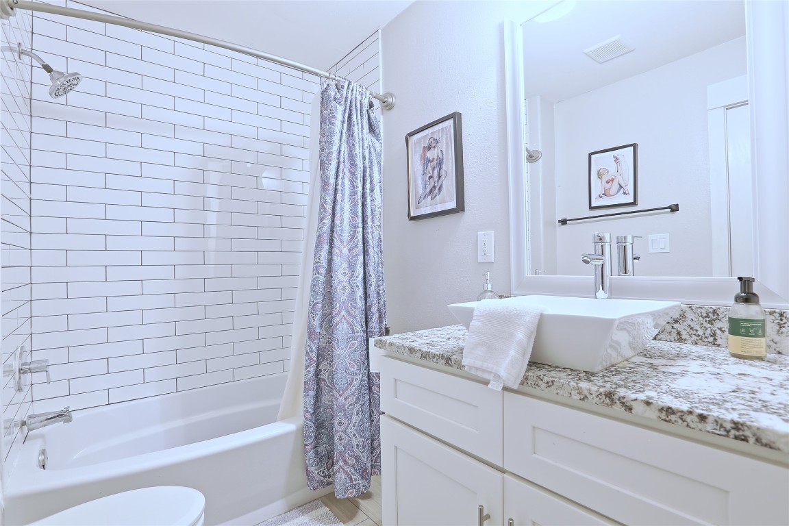4804 West Wind Trail, Unit 102 Austin, TX 78745 - Photo 20 of 24 a bathroom with a granite countertop sink and a bathtub