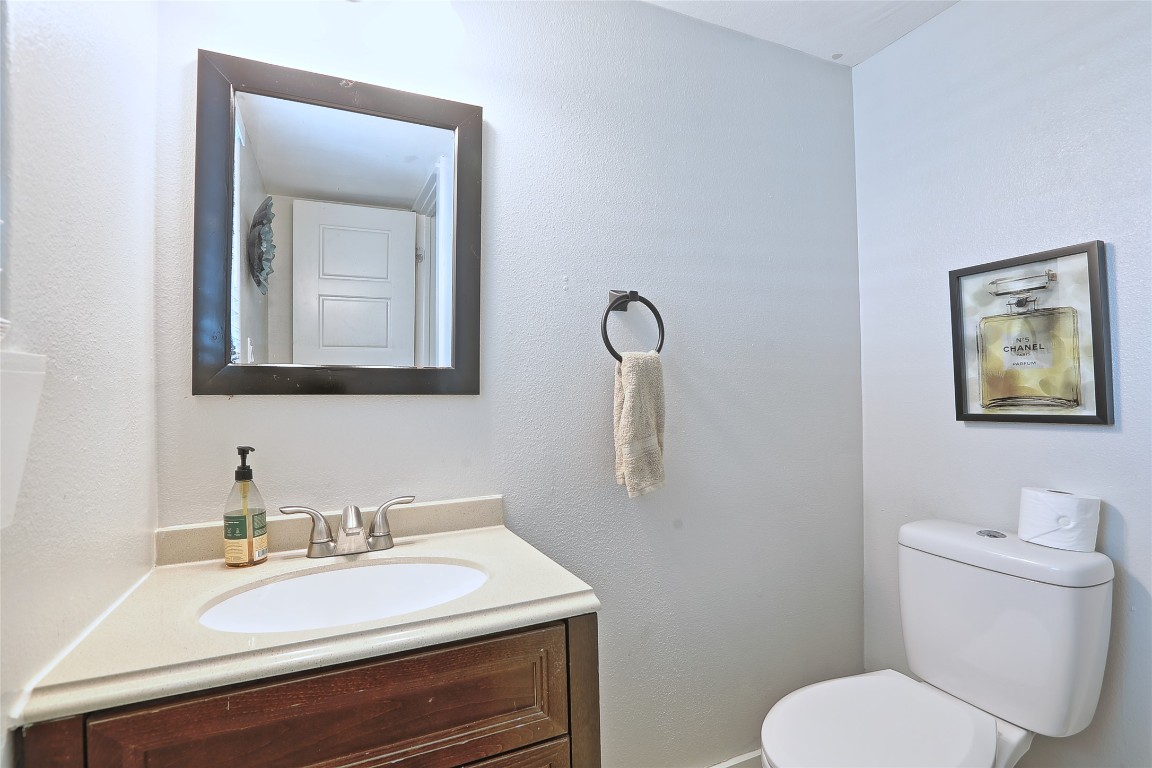 4804 West Wind Trail, Unit 102 Austin, TX 78745 - Photo 22 of 24 a bathroom with a toilet a sink and mirror