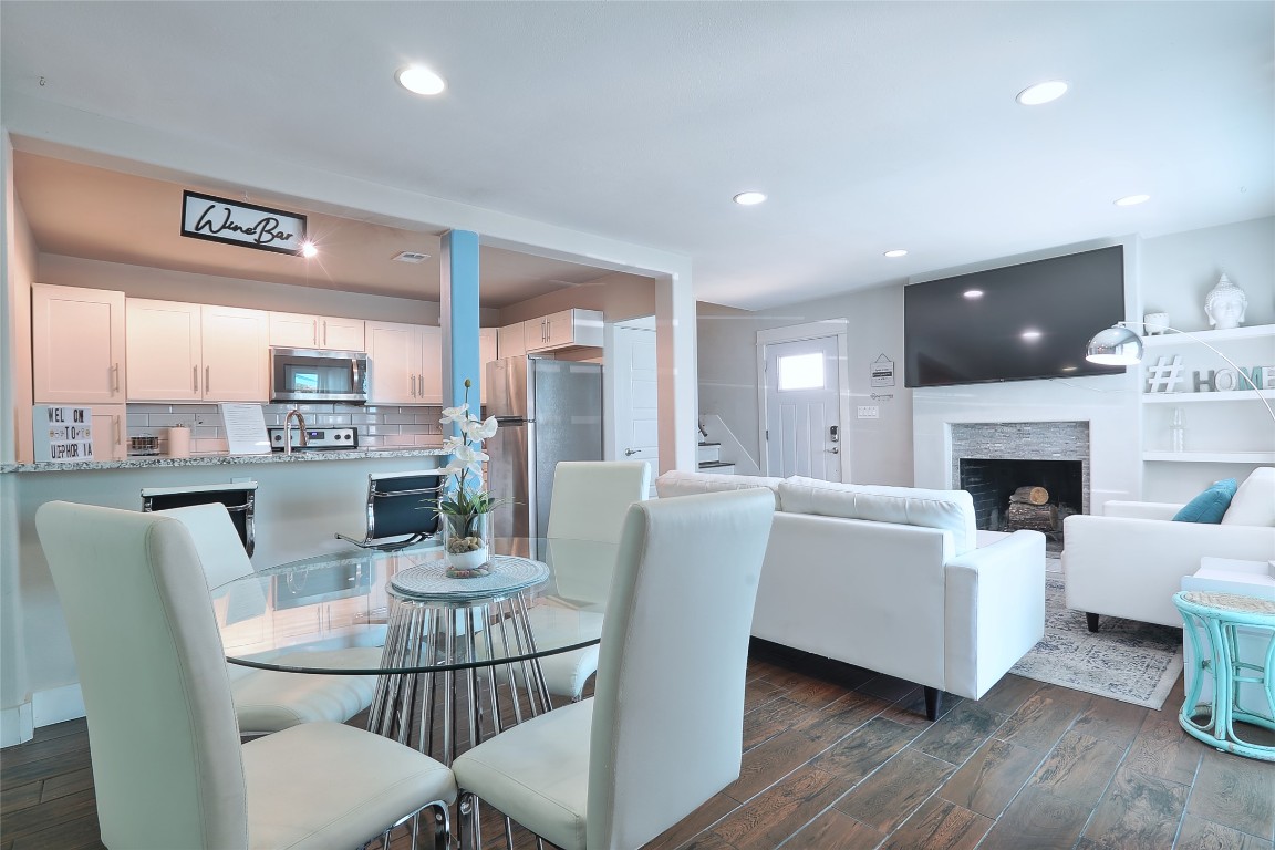 4804 West Wind Trail, Unit 102 Austin, TX 78745 - Photo 6 of 24 a dining room with furniture a fireplace and large windows