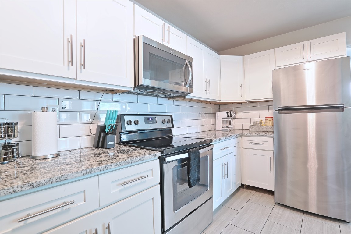 4804 West Wind Trail, Unit 102 Austin, TX 78745 - Photo 9 of 24 a kitchen with white cabinets and white appliances
