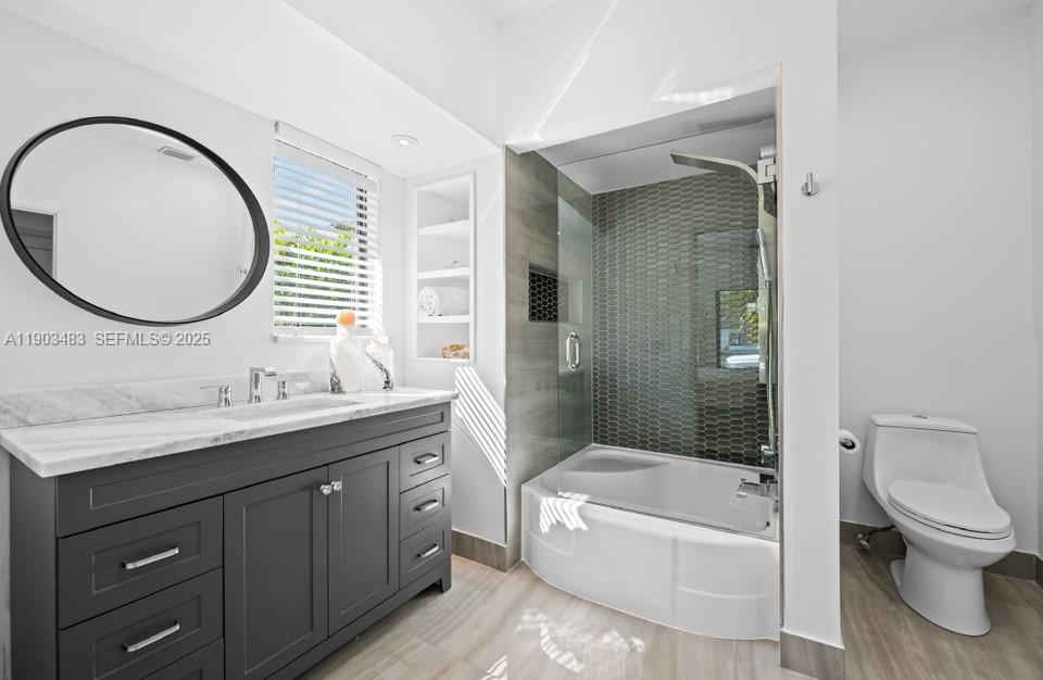 641 Island Road Miami, FL 33137 - Photo 11 of 16 a bathroom with a toilet a sink a bathtub and mirror