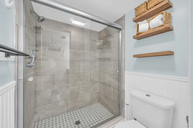 a bathroom with a shower a toilet and a window