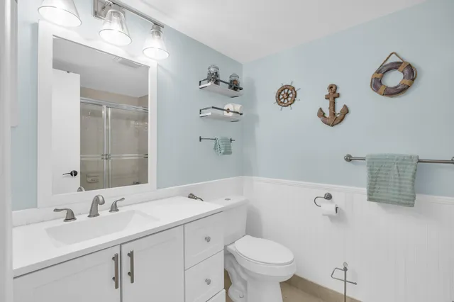 a bathroom with a sink a toilet and a mirror