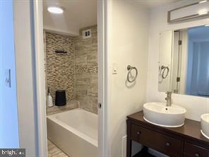 1836 Metzerott Road, Unit 901 Hyattsville, MD 20783 - Photo 13 of 20 a bathroom with a sink shower and a mirror
