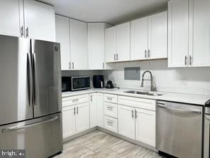 1836 Metzerott Road, Unit 901 Hyattsville, MD 20783 - Photo 3 of 20 a kitchen with cabinets and stainless steel appliances