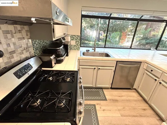 a view of a kitchen with a sink and wooden cabinets