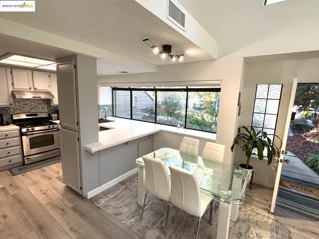 a view of a dining room with furniture large windows and wooden floor