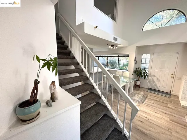 a dining room with wooden floor and stairs