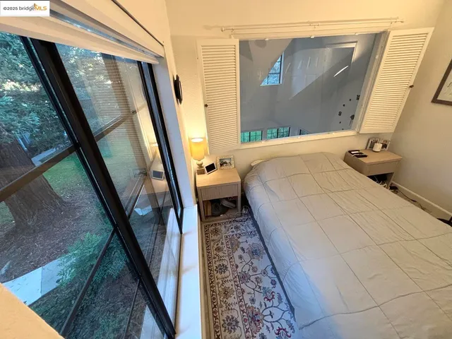 a bedroom with a bed window and a mirror