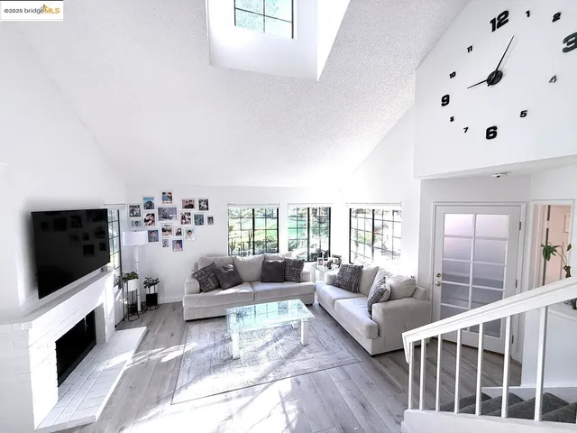 a living room with furniture a flat screen tv and a floor to ceiling window