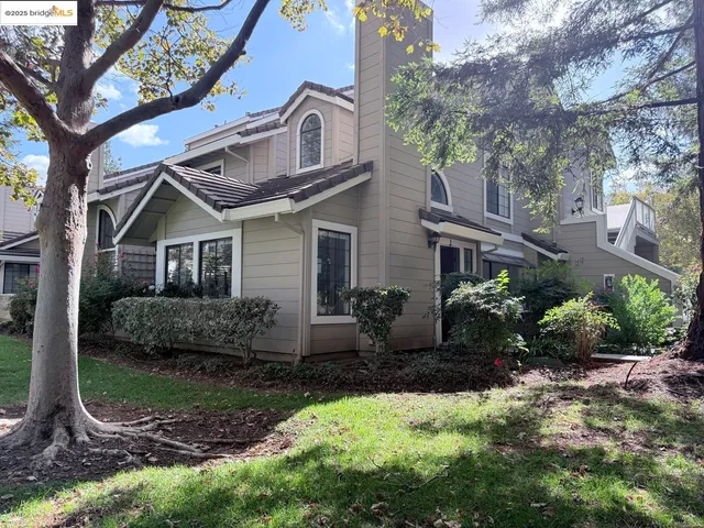 a view of a house with a yard and tree s