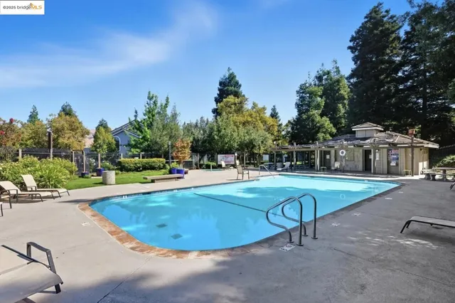a view of a swimming pool with sitting area and furniture