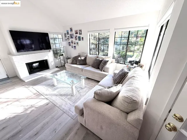 a living room with furniture a flat screen tv and a fireplace