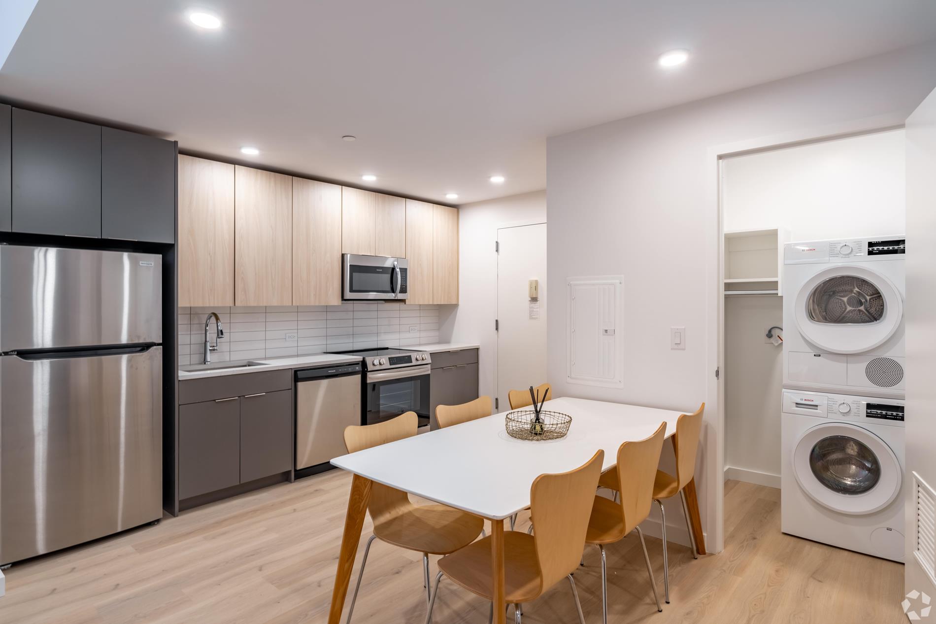 a kitchen with stainless steel appliances granite countertop a kitchen island a stove a table and chairs