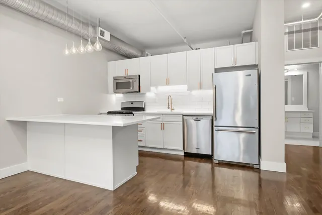 a kitchen with stainless steel appliances a refrigerator sink and microwave