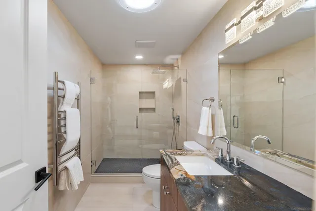 a bathroom with a double vanity sink toilet mirror and shower
