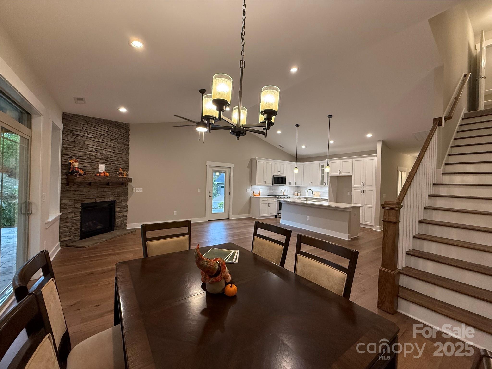 20 Craftsman Overlook Ridge Arden, NC 28704 - Photo 13 of 16 a view of a dining room and livingroom with furniture wooden floor a rug a fireplace and a chandelier