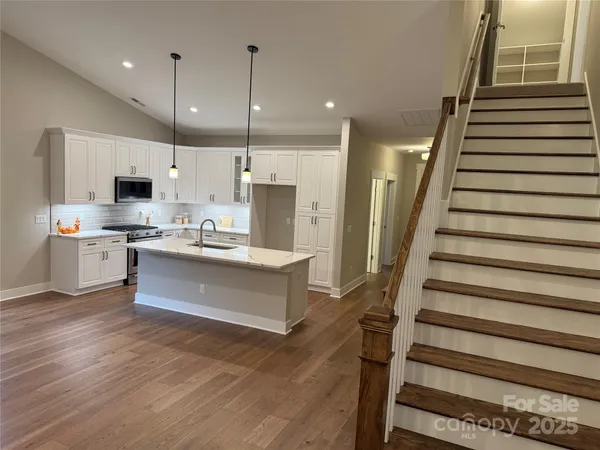 a kitchen with kitchen island granite countertop wooden floors granite top and stainless steel appliances