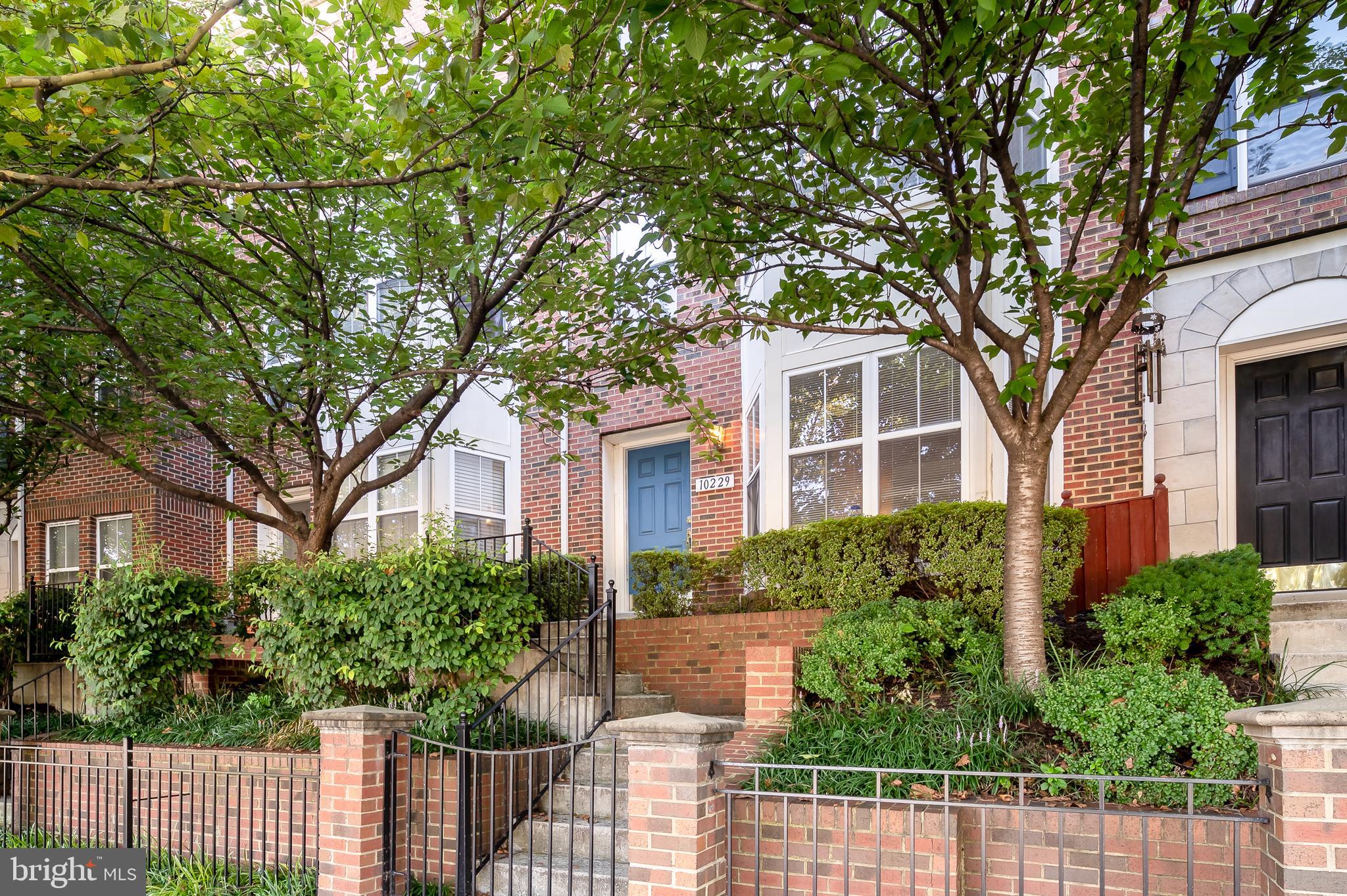 a front view of a house with a tree